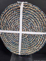 Top view of stacked braided straw placemats showing color and weave