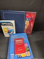 All five items grouped: photo album, Human Body book, Optimizer for Windows, Mosby dictionary, Webster’s dictionary