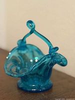 Front view of ruffled blue glass basket with handle