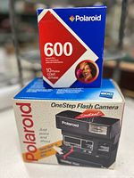 Camera box front showing Polaroid OneStep Flash camera image and film box on top
