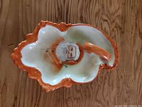 Top view of ceramic Santa dish showing handle, Santa image and orange rim