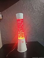 Full view of lava lamp lit showing red glitter