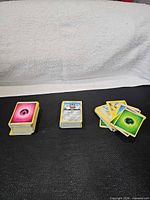 Three stacks of Pokémon cards: energy, basic, mixed