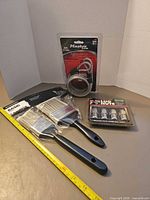 All items grouped: Master Lock cable, two paint brushes, lug nuts pack