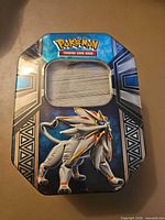 Top view of Pokémon TCG tin with stack of cards visible through window