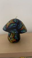 Front view of mushroom candle showing mosaic pattern and chip area