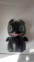 Front view of interactive Toothless figure showing face, wings, and overall condition