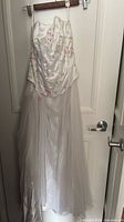 Full view of ivory corset gown with chiffon skirt and rosette detail