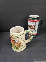 Both Budweiser steins side by side showing size and handle style