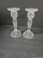 Front view of both clear glass candlestick holders