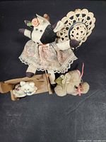 Group shot: cow doll, wooden chair with bonnet, wooden cradle, kitten figurine, plush bear