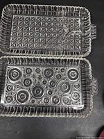 Two rectangular clear pressed glass plates with different base patterns