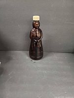 Full view of amber glass Mrs. Butterworth bottle with lid