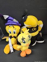 Three plush toys grouped: wizard Tweety, small Tweety, Buzz mascot