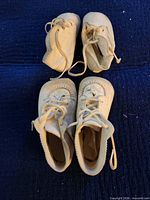 Two pairs vintage cream leather baby shoes front view