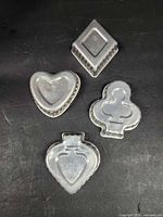 Top view of four metal cookie cutters showing shapes and fluted edges