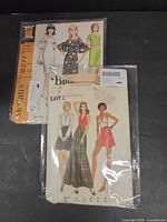 Front view of both vintage sewing pattern envelopes in plastic sleeves