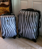 Both zebra-pattern suitcases side by side