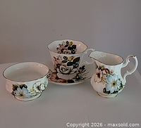 Four-piece Royal Albert bone china set showing sugar bowl, saucer with teacup, and creamer