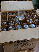 Open carton showing grid divider with tumblers and one glass upright on top