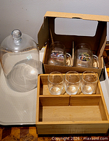 Overview showing cloche, boxed mugs, tumblers in wooden case