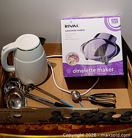 Lot overview showing boxed omelette maker, kettle, ladles and scoop