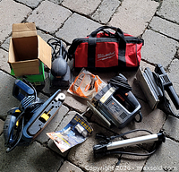 All items laid out on paving stones including Milwaukee bag, power tools, pump and accessories
