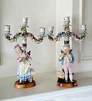 Both porcelain figurine candelabras front view showing overall design