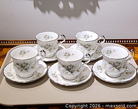 Full set of five teacups and five saucers displayed