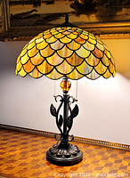 Full view of lit stained glass lamp showing shade colors and base
