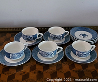 Full set layout with cups on saucers and stack of plates