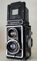 Front view showing twin Zeiss Ikon lenses, nameplate, textured body, viewfinder hood