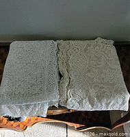 Two folded lace tablecloths on table