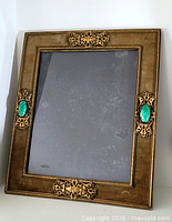 Full view of rectangular gilt metal frame with glass and green cabochon side accents