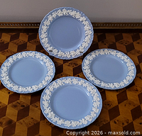 Four Wedgwood lavender plates with white grapevine border displayed on patterned surface