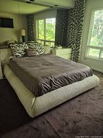 Angled room view showing full platform bed, mattress, cushions, and surrounding frame