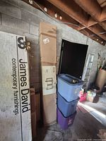 Tall cardboard box containing gazebo standing upright against wall