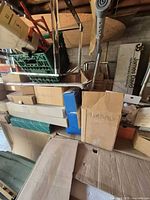 Stacked cardboard boxes labeled plumbing and assorted hardware items