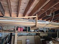 Wide shot of rack holding stacked lumber, trim, plywood sheets, bamboo poles