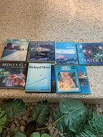 Group shot of eight hardcover books laid out on floor