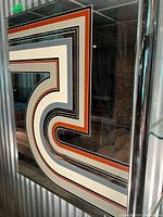 Full view of mirror showing chrome frame and geometric design