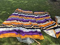 Full view of two striped drapery panels laid on grass