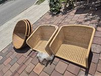 Three stacked round wicker seat inserts and two boxy inserts displayed on driveway