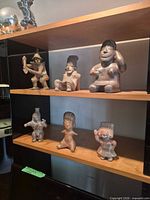 All six figurines displayed on shelving