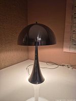 Front view of chrome tulip lamp powered on