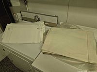 Stacked white leather panels on appliance, showing stitched edges and slotted holes
