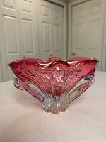 front view of pink art glass bowl showing clear base and folded rim