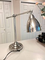 Full view of brushed nickel adjustable desk lamp on countertop