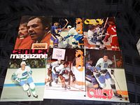 Six vintage Vancouver Canucks program magazines from 1970s displayed