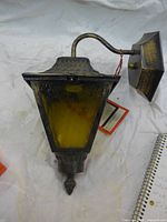 Full view of lantern showing shape, glass panels, arm and backplate